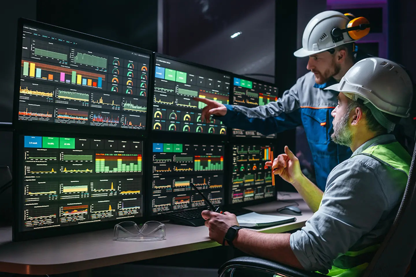 Engenheiro sênior e trabalhador acompanhando a linha de produção da fábrica em telas com o software Industry 4.0. 