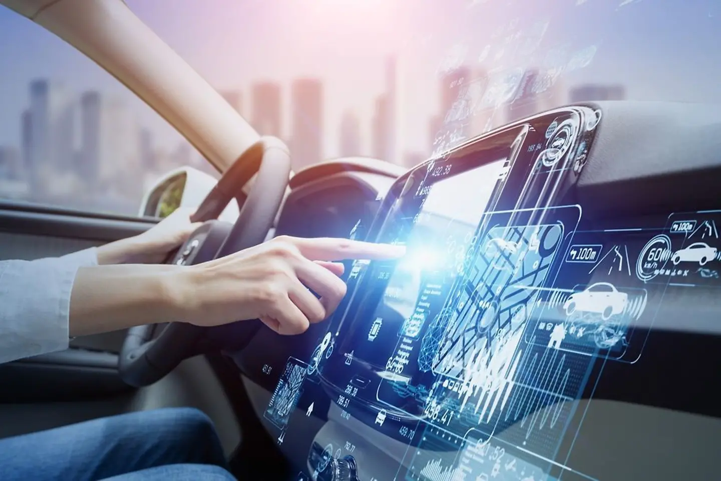 Interior of a vehicle, woman's hand on the steering wheel, other hand operating navigation system.