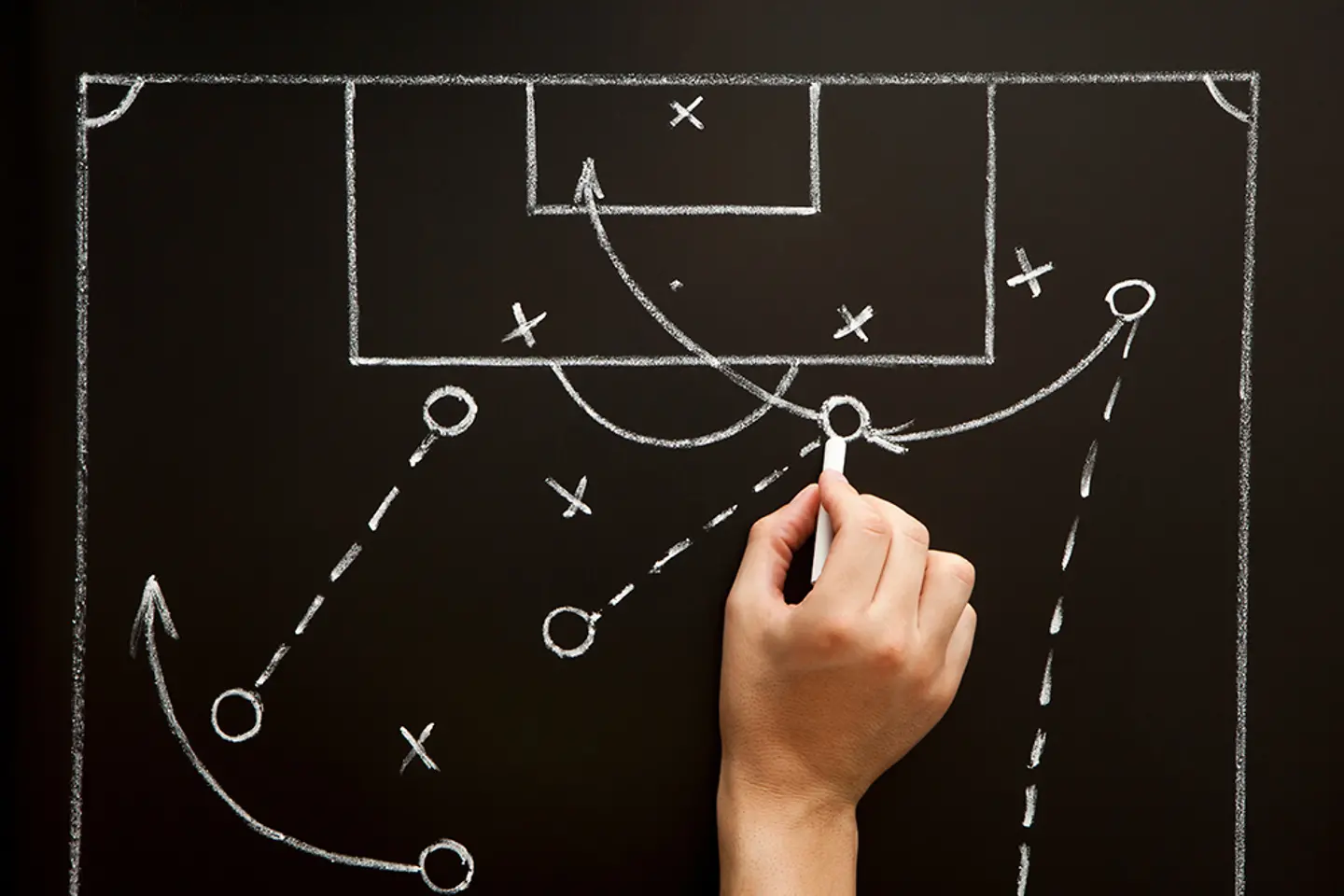 Ein Trainer entwirft in der Umkleidekabine eine Strategie für ein Fußballspiel.