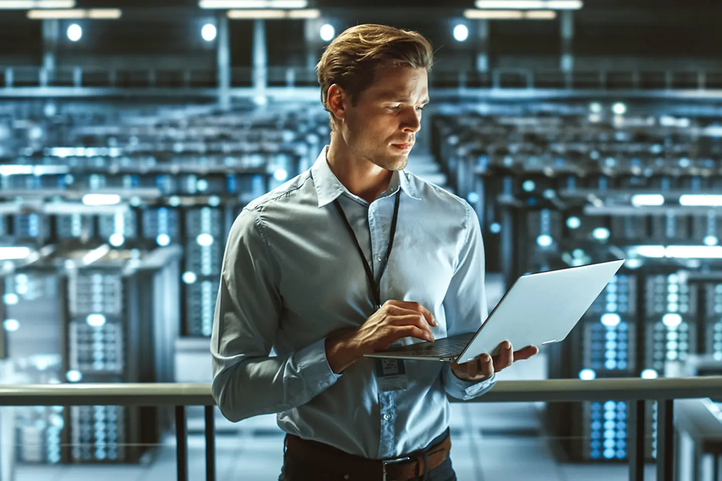 Porträt eines IT-Spezialisten mit Laptop im Rechenzentrum.