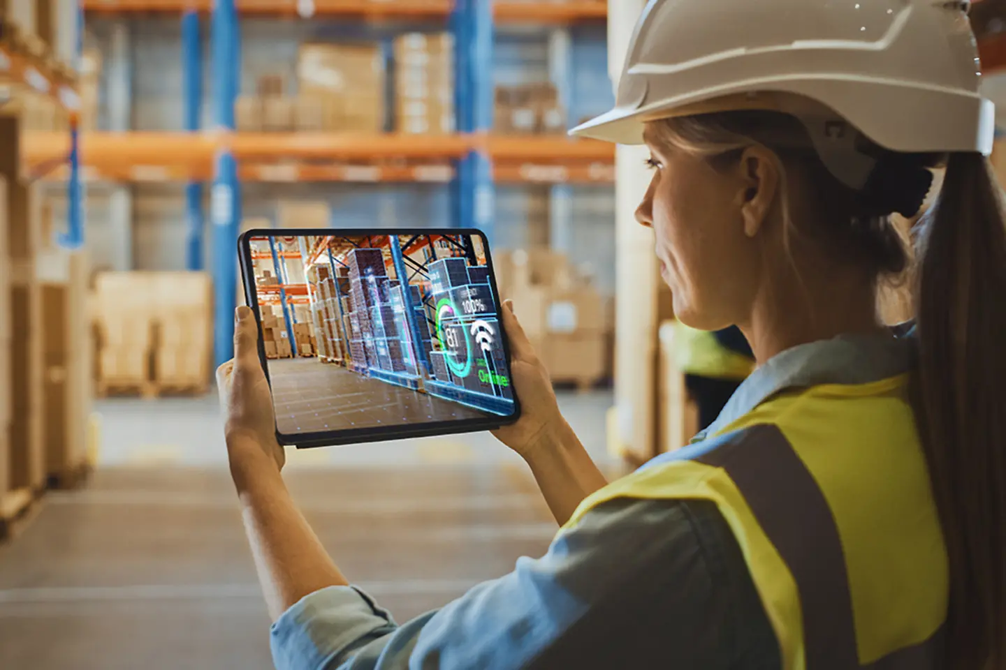 Jovem funcionária fazendo inventário no armazém usando realidade aumentada com um tablet digital