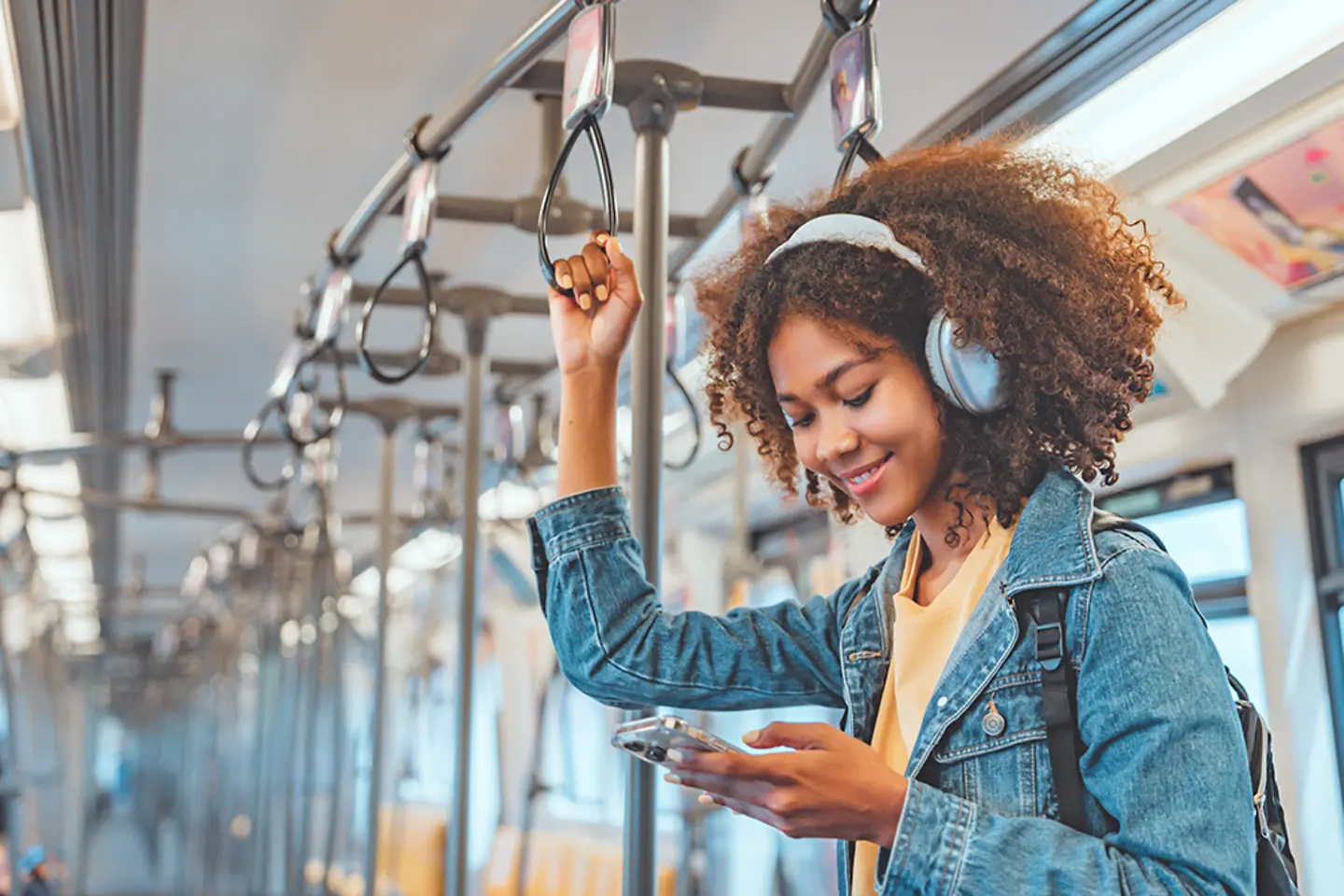 Gelukkig kijkende treinreiziger luistert naar muziek op haar smartphone
