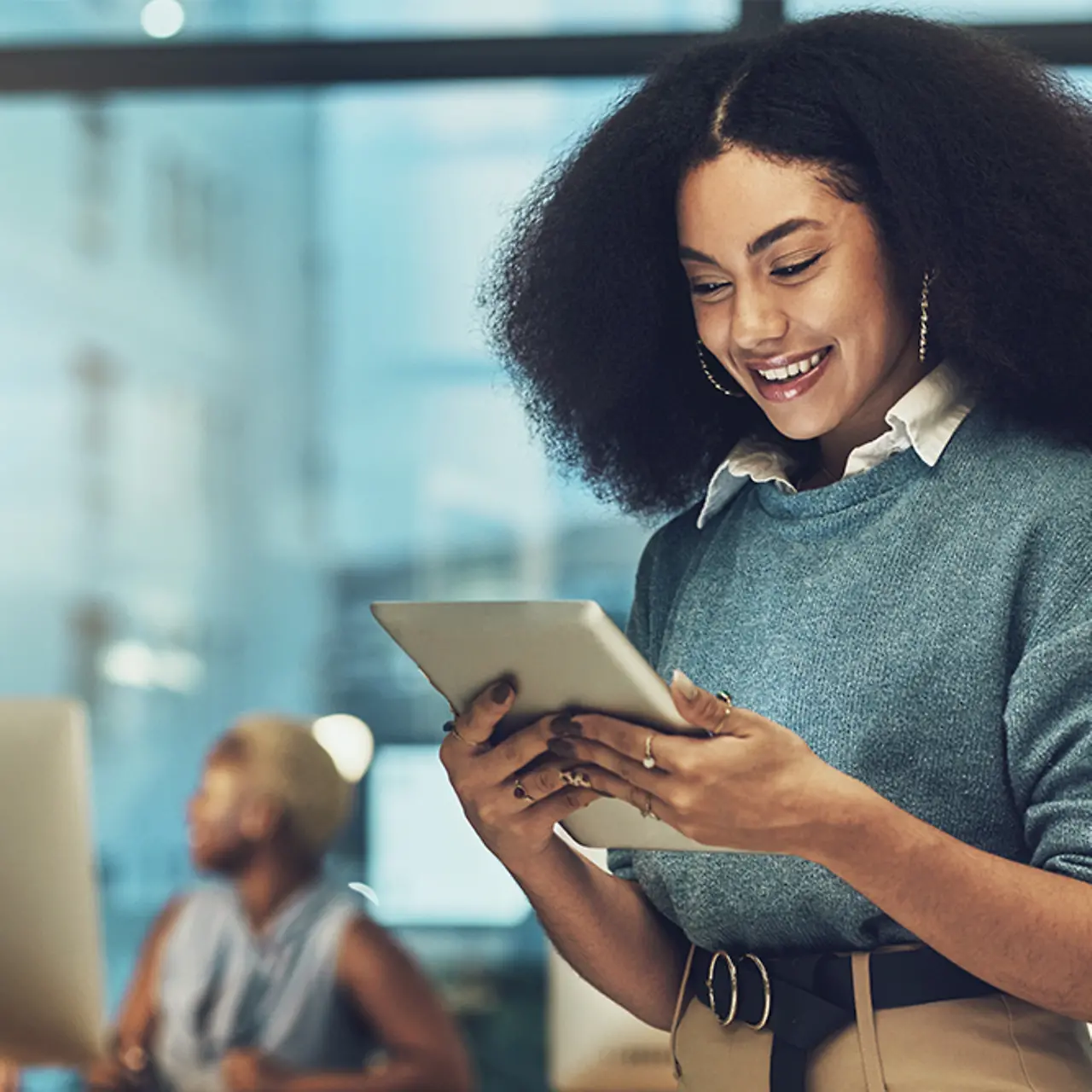 Geschäftsfrau im Büro schaut auf ein Tablet