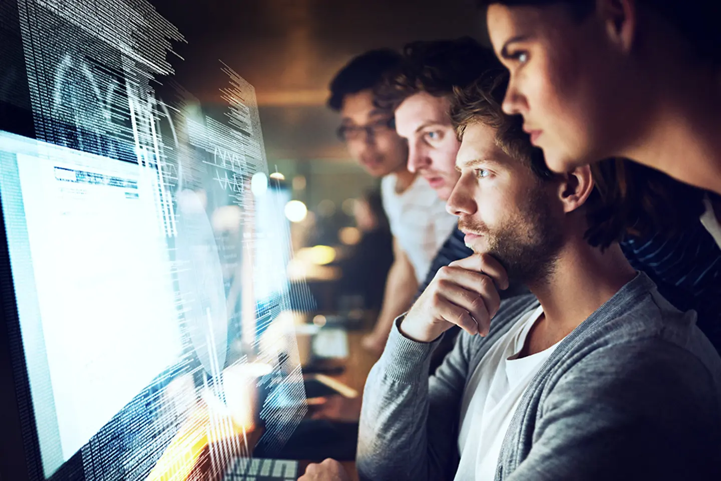 Eine Gruppe von Programmierern arbeitet nachts an einem Computercode
